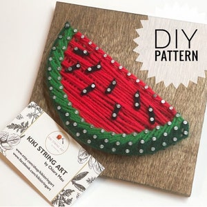 Può includere: Modello di string art fai-da-te di una fetta di anguria su un pannello di legno. Il modello include filo rosso per l'anguria, filo verde per la buccia e filo nero per i semi. Il pannello ha un'etichetta bianca con il testo "DIY PATTERN" su di essa.