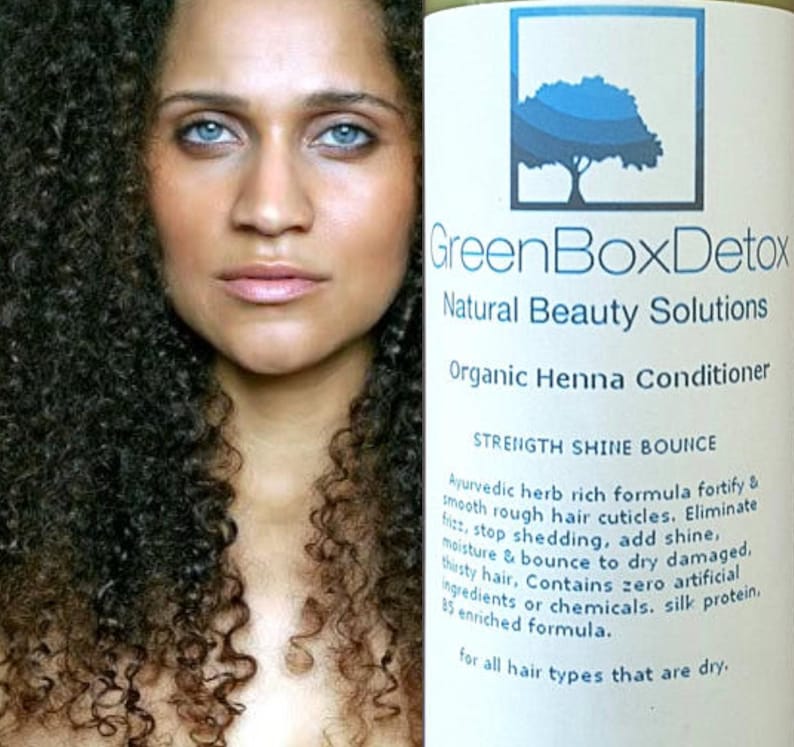 May include: A white bottle with a green label that reads "GreenBoxDetox Natural Beauty Solutions Organic Henna Conditioner Strength Shine Bounce". The label also includes a description of the product's benefits, including that it is an Ayurvedic herb rich formula that fortifies and smooths rough hair cuticles, eliminates frizz, stops shedding, adds shine, and moisturizes and bounces dry damaged hair. The label also states that the product contains zero artificial ingredients or chemicals and is enriched with silk protein. The label also states that the product is for all hair types that are dry.