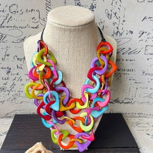 May include: A white ceramic mug with a black handle and the text "But First, Coffee" in a black, handwritten-style font. The mug is on a white surface.