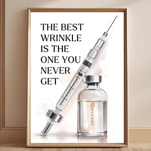 May include: A framed print with a syringe and a vial, accompanied by the text "THE BEST WRINKLE IS THE ONE YOU NEVER GET". The artwork uses a watercolour style and soft, neutral tones, ideal for a spa or medical setting.