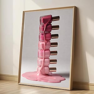 May include: A framed art print featuring a stack of nail polish bottles in varying shades of pink. The nail polish appears to be dripping down, creating a puddle at the base. The bottles have gold-colored caps.