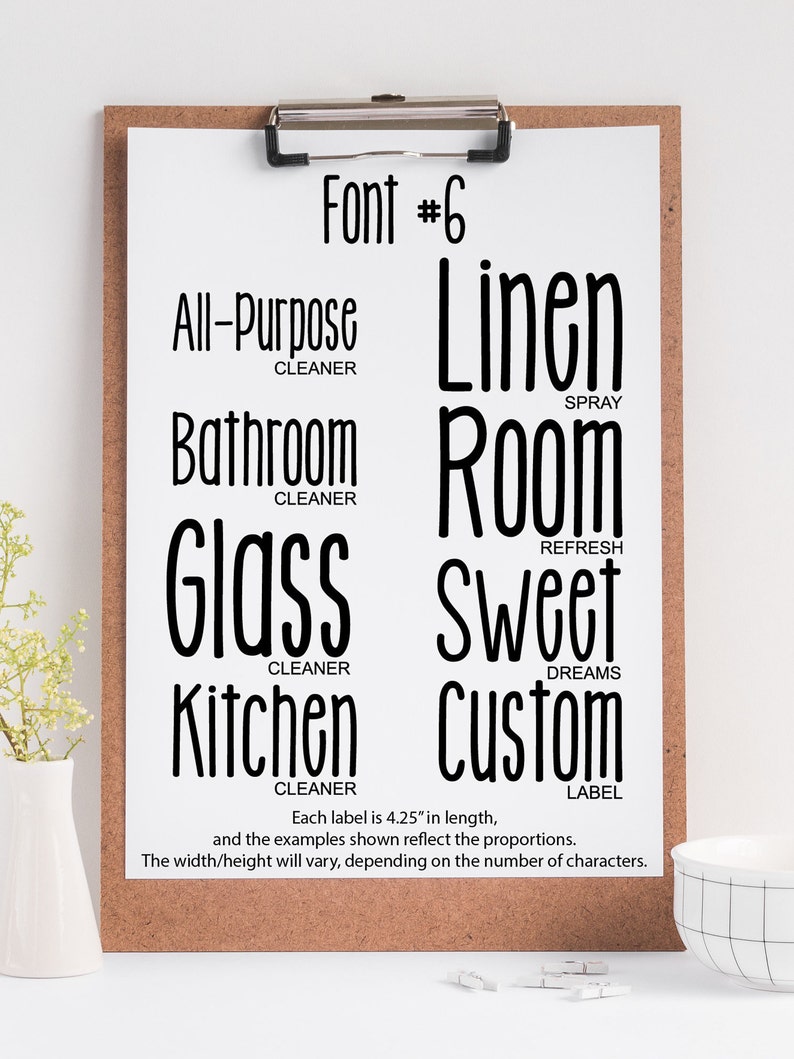 May include: A white board with a black clipboard attached to it. The clipboard has a sheet of paper with the text "Font #6" at the top. Below the text are eight labels with different text and descriptions, such as "All-Purpose Cleaner", "Linen Spray", "Bathroom Cleaner", "Room Refresh", "Glass Cleaner", "Sweet Dreams", "Kitchen Cleaner", and "Custom Label". Each label is 4.25 inches in length.