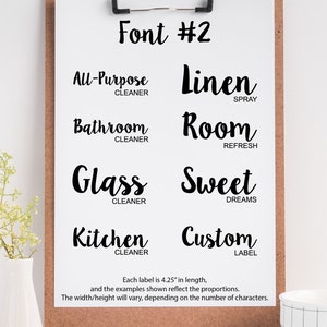 May include: A black and white image of a clipboard with a handwritten font style guide. The font is called "Font #2" and is used for labels. The labels are 4.25 inches long and include the following text: "All-Purpose Cleaner", "Linen Spray", "Bathroom Cleaner", "Room Refresh", "Glass Cleaner", "Sweet Dreams", "Kitchen Cleaner", and "Custom Label".