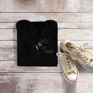 Puede incluir: Camiseta negra con un diseño de diente de león blanco y el texto "Just Breathe".