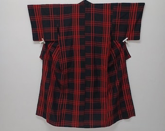 Puede incluir: Un kimono de cuadros negros y rojos con un diseño tradicional japonés.