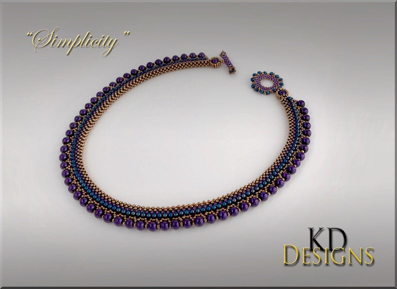May include: A purple and copper beaded necklace with a toggle clasp. The necklace is called "Simplicity".