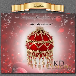 Op de afbeelding: Een rode kerstbal met kralen, gouden accenten en een kralenrand. De bal is gelabeld met "Christmas Ornament "2020" "My Sweetheart" en "KD Designs".