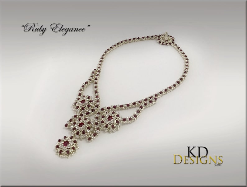 Peut inclure: Un collier de perles argent&eacute;es et rouges avec un motif floral. Le collier s'appelle "Ruby Elegance".