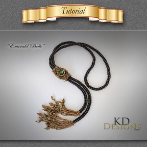 Könnte beinhalten: Eine schwarze und goldene Perlenkette mit einem grünen Edelstein-Anhänger und einem Quasten. Die Kette heißt "Emerald Belle" und ist ein Design von KD Designs.