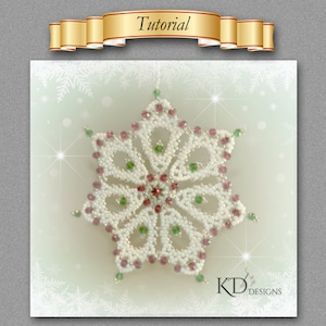May include: A white beaded snowflake ornament with red and green accents. The snowflake is a six-pointed star with a beaded centre and a loop for hanging. The ornament is on a white background with a snowflake pattern.