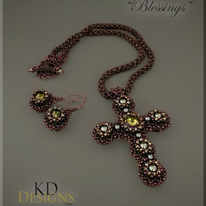 May include: A beaded cross necklace and earrings set in brown and silver tones. The necklace features a cross pendant with a beaded design and the earrings are teardrop shaped with a beaded design. The set is labelled "Blessings".