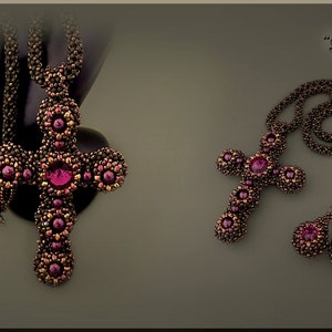May include: A beaded cross necklace and earrings set in a dark brown and burgundy colour scheme. The necklace features a large cross pendant with a large burgundy gemstone in the centre. The earrings are teardrop shaped with a burgundy gemstone in the centre. The set is labelled "Blessings".