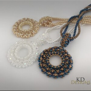 May include: Three beaded necklaces with circular pendants. The pendants are made of small beads in different colours and patterns. The necklaces are in white, gold, and blue.