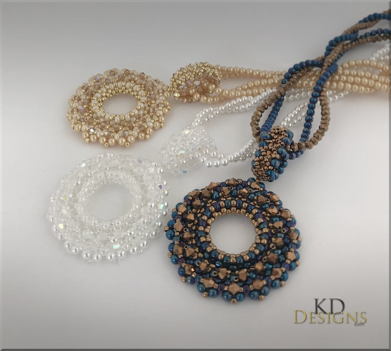 May include: Three beaded necklaces with circular pendants. The pendants are made of small beads in different colours and patterns. The necklaces are in white, gold, and blue.
