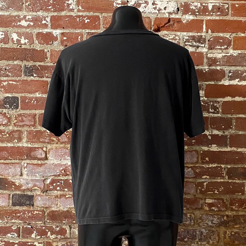 May include: A black short-sleeved t-shirt with a crew neck.