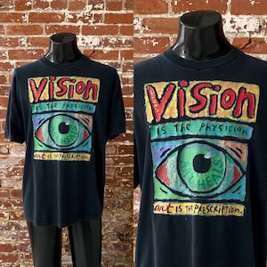 May include: Black t-shirt with a colorful graphic print of an eye with the text "Vision is the Physician, Art is the Prescription."