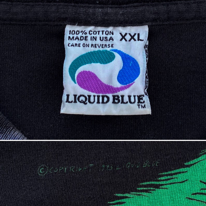 Może przedstawiać: Czarna koszulka z metką Liquid Blue. Na metce napisano "100% Bawełna, Made in USA, XXL, Pielęgnacja na odwrocie". Logo Liquid Blue to stylizowany wz&oacute;r w kolorze morskim, fioletowym i niebieskim. Prawa autorskie brzmią "&copy; COPYRIGHT 1993 LIQUID BLUE."
