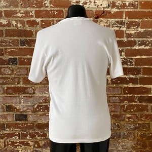 May include: White short-sleeved t-shirt with a crew neck.