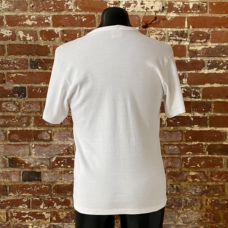 May include: White short-sleeved t-shirt with a crew neck.