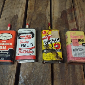 May include: Four vintage metal cans with labels, including "Bonded Household Oil," "Tru-Test Quality Paints," "Lige Wrench," and "Renuzit Mover." The cans are rectangular, with red, white, yellow, and pink color schemes. Each can is approximately 4 fl oz.