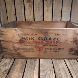 May include: A vintage wooden crate with a label that reads "Sun Graze Corner Beef Product of Paraguay" and "International Products Corp. South Amer."