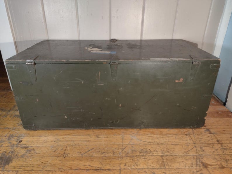 May include: A vintage green wooden storage chest with metal hardware and a worn surface.