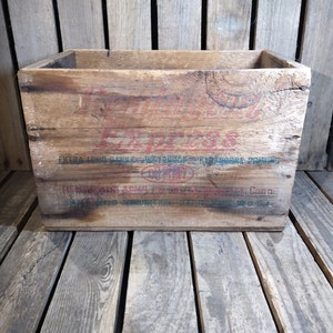 May include: A vintage wooden crate with the words "Express" and "Remington Arms Co. Inc. Bridgeport, Conn." printed on the front. The crate is weathered and has a rustic appearance.