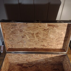 May include: Open wooden storage trunk with a metal frame and a plywood interior.