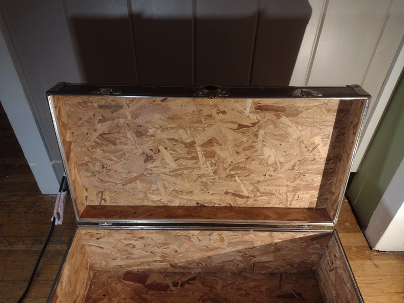 May include: Open wooden storage trunk with a metal frame and a plywood interior.