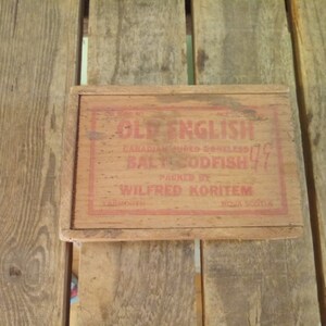 May include: A wooden box with a red label that reads "Old English Canadian Cured-Boneless  Bally Codfish" packed by "Wilfred Koritem Yarmouth Nova Scotia".
