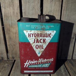 May include: A vintage, red and green metal can labeled "Hydraulic Jack Oil" with the text "Hein-Werner Corporation Hydraulic Jacks Waukesha, Wisconsin, U.S.A." and "Assures best operation of hydraulic jacks and equipment".