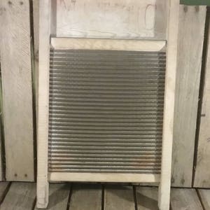 Puede incluir: Un antiguo lavadero de madera con una superficie corrugada de metal. El lavadero tiene un marco de madera y está en buen estado.