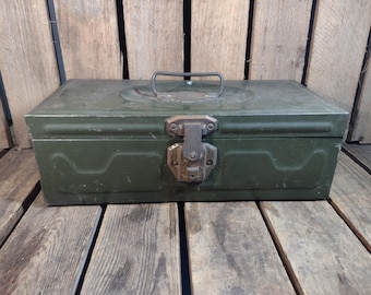 May include: A green metal box with a hinged lid and a metal latch. The box has a worn, vintage look.