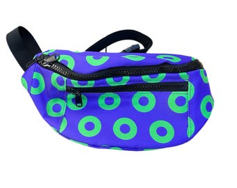 May include: A blue fanny pack with a green donut pattern. The pack has a black zipper and strap.