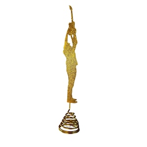 May include: A gold glitter guitar player figurine with a spiral base. The figure is holding a guitar above their head. The figurine is a decorative item, likely for a Christmas tree or other holiday display.
