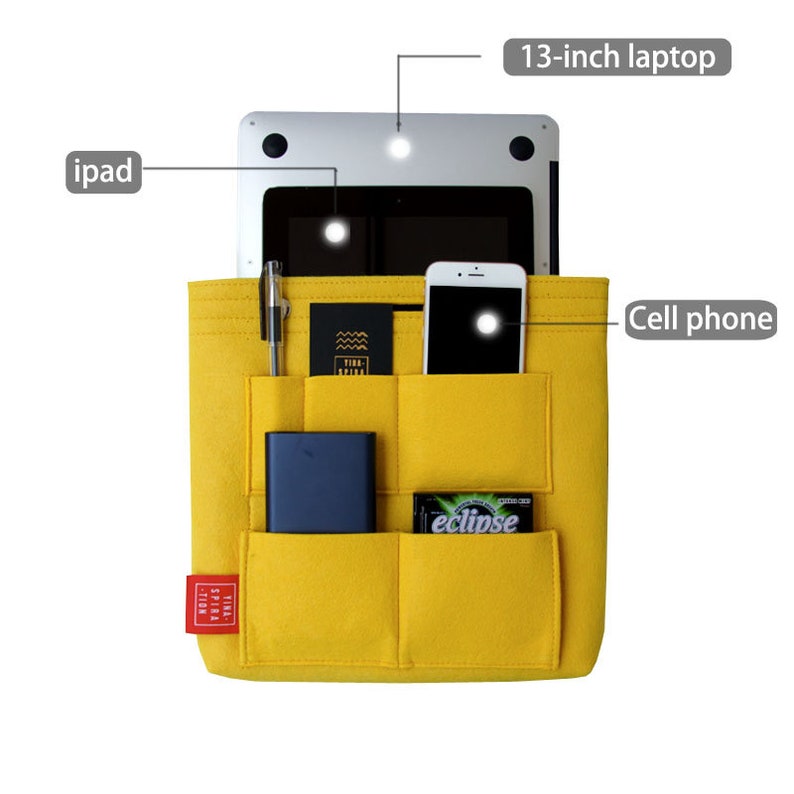 May include: A yellow felt organizer with multiple pockets, holding a 13-inch laptop, iPad, cell phone, pen, cards, a power bank, and a pack of gum. The organizer has a red label with white text.