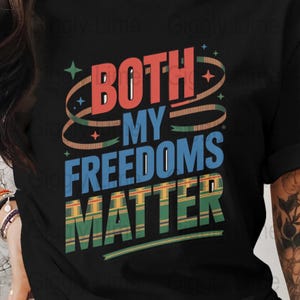 Könnte beinhalten: Schwarzes T-Shirt mit dem Text "BOTH MY FREEDOMS MATTER" in Rot, Blau und Grün. Das Design beinhaltet dekorative Wirbel und Sterne, die ein kühnes und farbenfrohes Statement erzeugen.