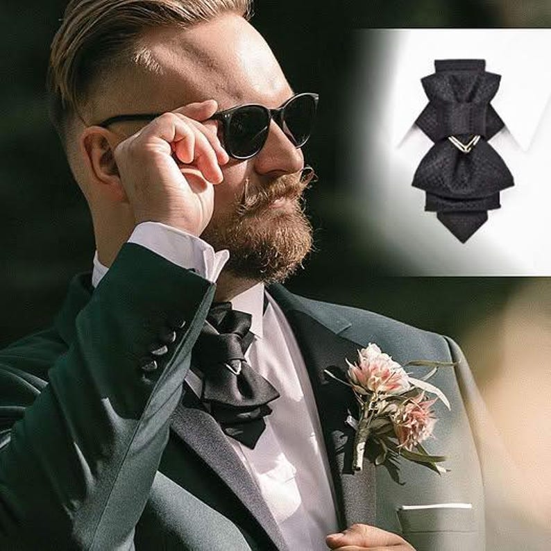 Groom wearing black vertical bow tie with dark green wedding suit, handmade sculptural necktie by RutyDesign, modern alternative bow tie for wedding, statement neckwear for men, pre-tied formal tie, unique groom accessory, handmade in Lithuania
