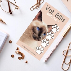以下が含まれることがあります： ピンクのメモ帳で、前面に「Vet Bills」と「Each Pad =」の文字が書かれています。メモ帳の右側には白い肉球の模様が描かれています。メモ帳の左側には青い目のシャム猫が描かれています。メモ帳は白い表面の上に置かれています。