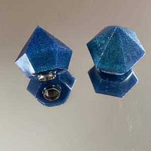 Può includere: Due tappi per bottiglia a forma di diamante blu con glitter e un inserto in metallo argentato.
