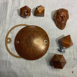 Peut inclure: Un ensemble de six boutons décoratifs dorés avec un design géométrique. Les boutons ont une finition scintillante et sont parfaits pour ajouter une touche d'élégance à n'importe quelle pièce.