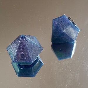 Può includere: Due ornamenti blu a forma di diamante con finitura scintillante.