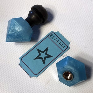 Può includere: Due tappi per bottiglie in resina blu chiaro con un biglietto a forma di stella con il numero 2176908 stampato su di esso. Un tappo per bottiglia è a forma di diamante e l'altro è a forma esagonale.
