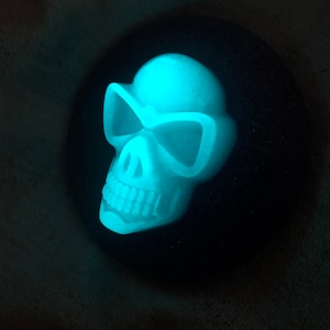 Peut inclure: Un crâne bleu fluorescent avec des lunettes de soleil, une décoration d'Halloween.