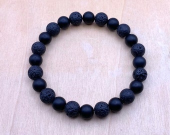 May include: A black beaded bracelet with alternating smooth and textured beads.