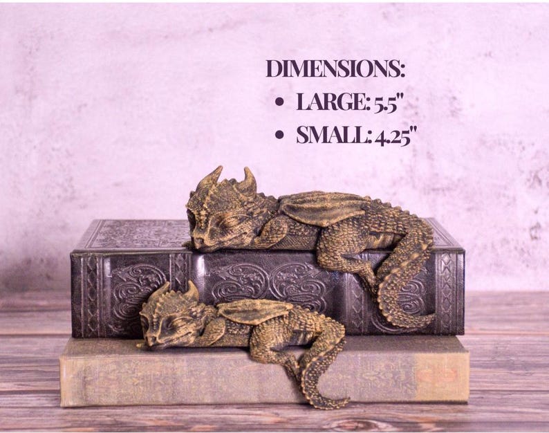 May include: Two detailed dragon figurines, one large at 5.5 inches and one small at 4.25 inches, rest on antique books. The dragons are bronze-colored with textured scales and wings. The books are dark with embossed designs.
