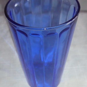 May include: A cobalt blue glass drinking glass with vertical ridges.