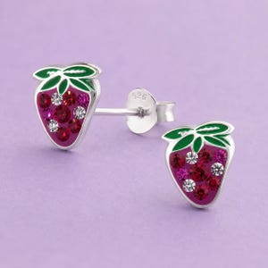 May include: A pair of sterling silver stud earrings shaped like strawberries. Each earring features green enamel leaves and a cluster of embedded red, pink, and clear crystals. The back of the earring post is clearly stamped with 925.