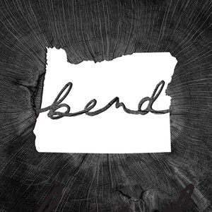 May include: Black and white image of the state of Oregon with the word "Bend" written in cursive inside the outline of the state.
