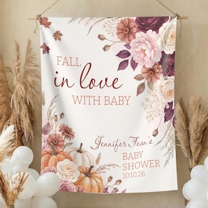 May include: A rectangular fabric backdrop featuring a fall-themed floral design with pumpkins, dried grasses, and roses in shades of orange, burgundy, and cream. The text reads Fall in love with baby, Jennifer Fean's BABY SHOWER, and 10.10.26.